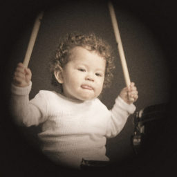 Toddler holding junior drumsticks